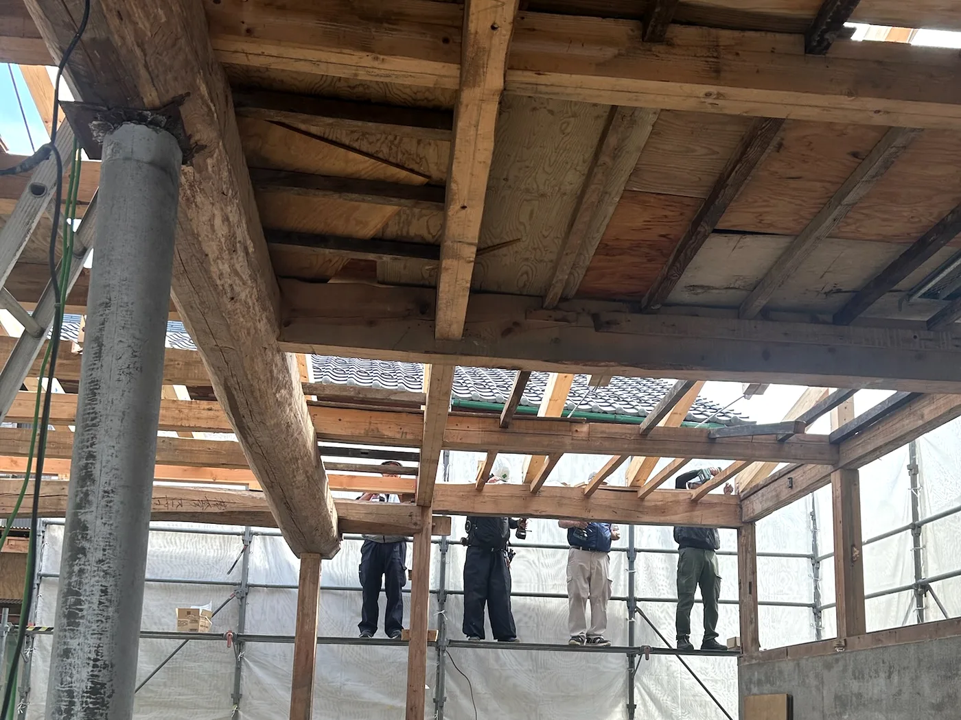 Inside during construction. A carpenter works on scaffolding under the old beams that were kept